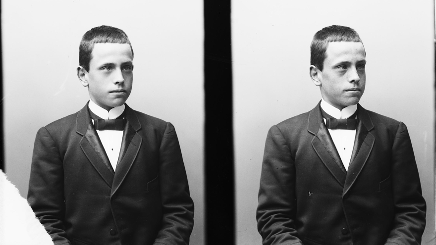 En pojke i kavaj i början av 1900-talet i ett svartvitt foto.