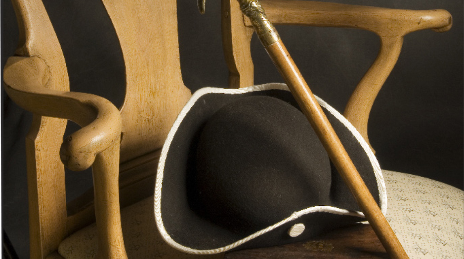 En hatt och käpp ligger i en 1700-talsstol.