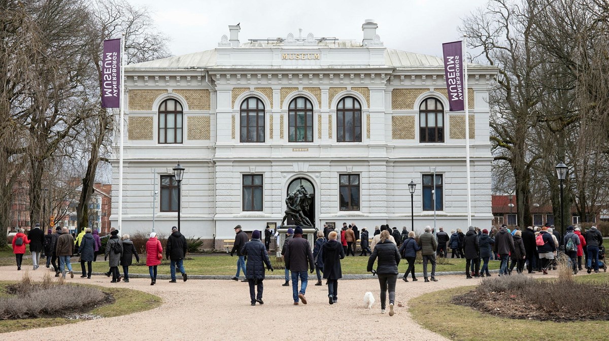 En grupp människor går mot Vänersborgs museum.