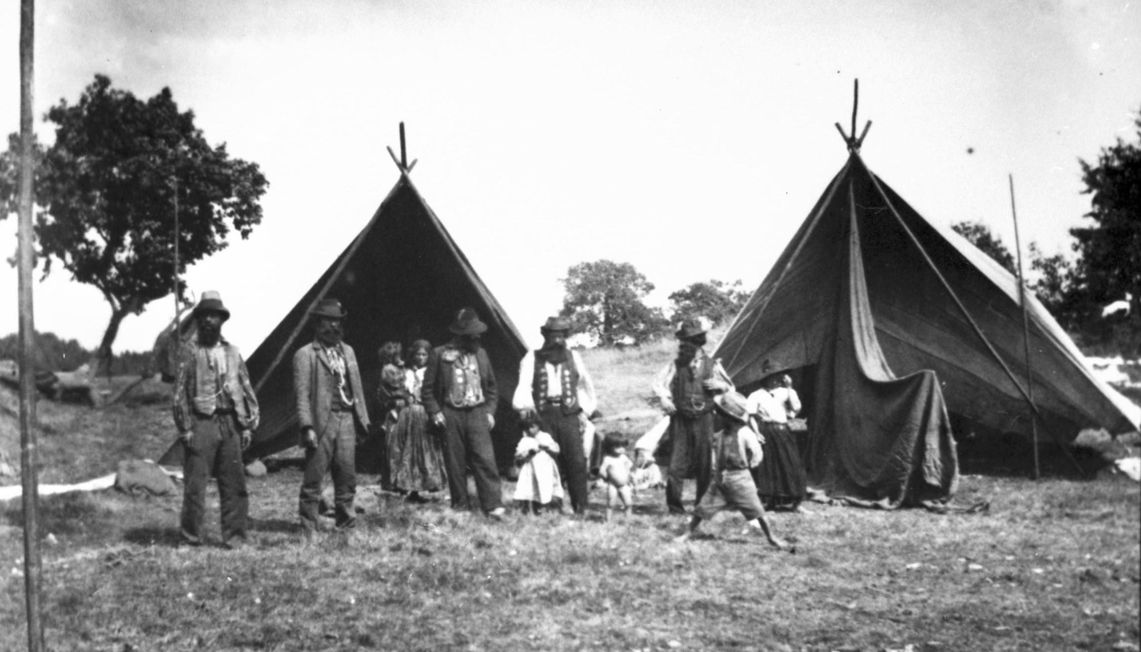 Personer stående framför två tält.