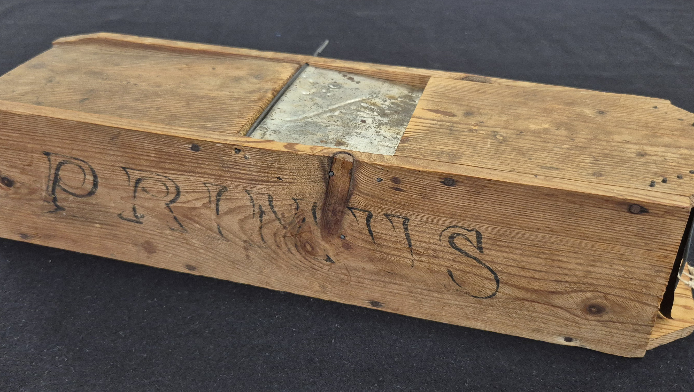 En äldre råttfälla i en trälåda som det står Primus på.