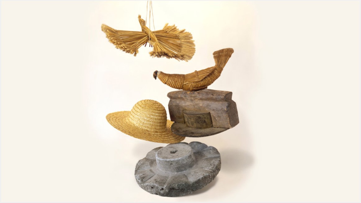 Silleben med hatt, hattpress och halmfåglar.