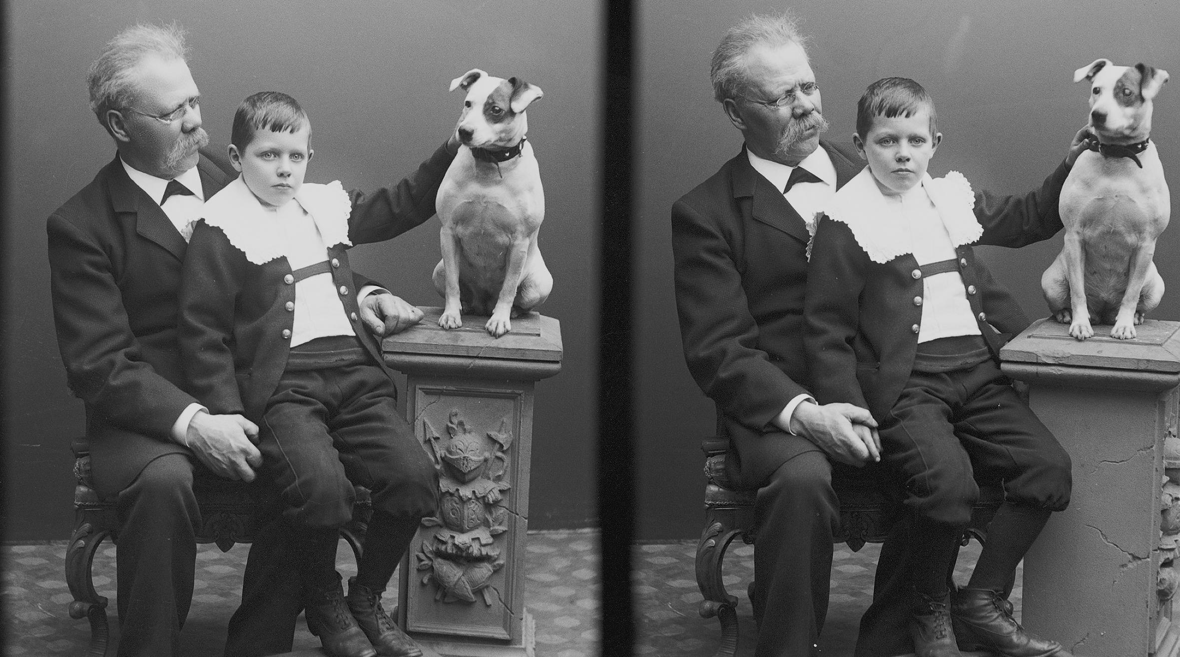 Ateljéfoto med man och gosse sittande på en stol och en hund på en pedistal