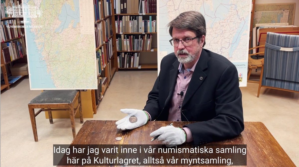 Peter Johansson visar upp mynt från den karolinska tiden.